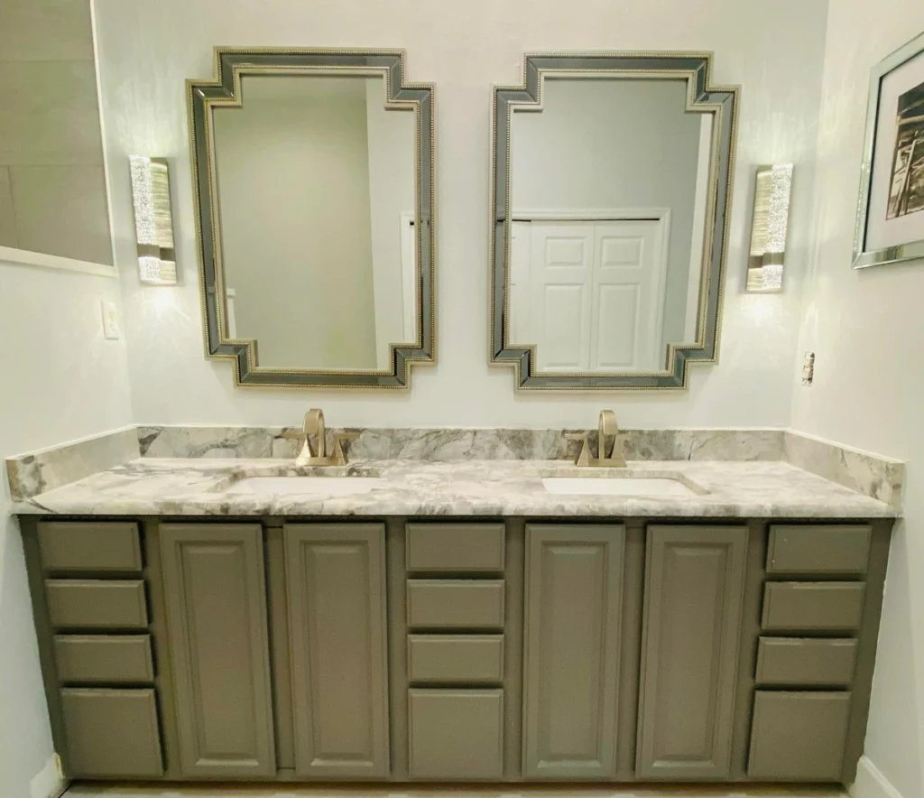 Bathroom remodel with double vanity, marble countertop, and framed mirrors